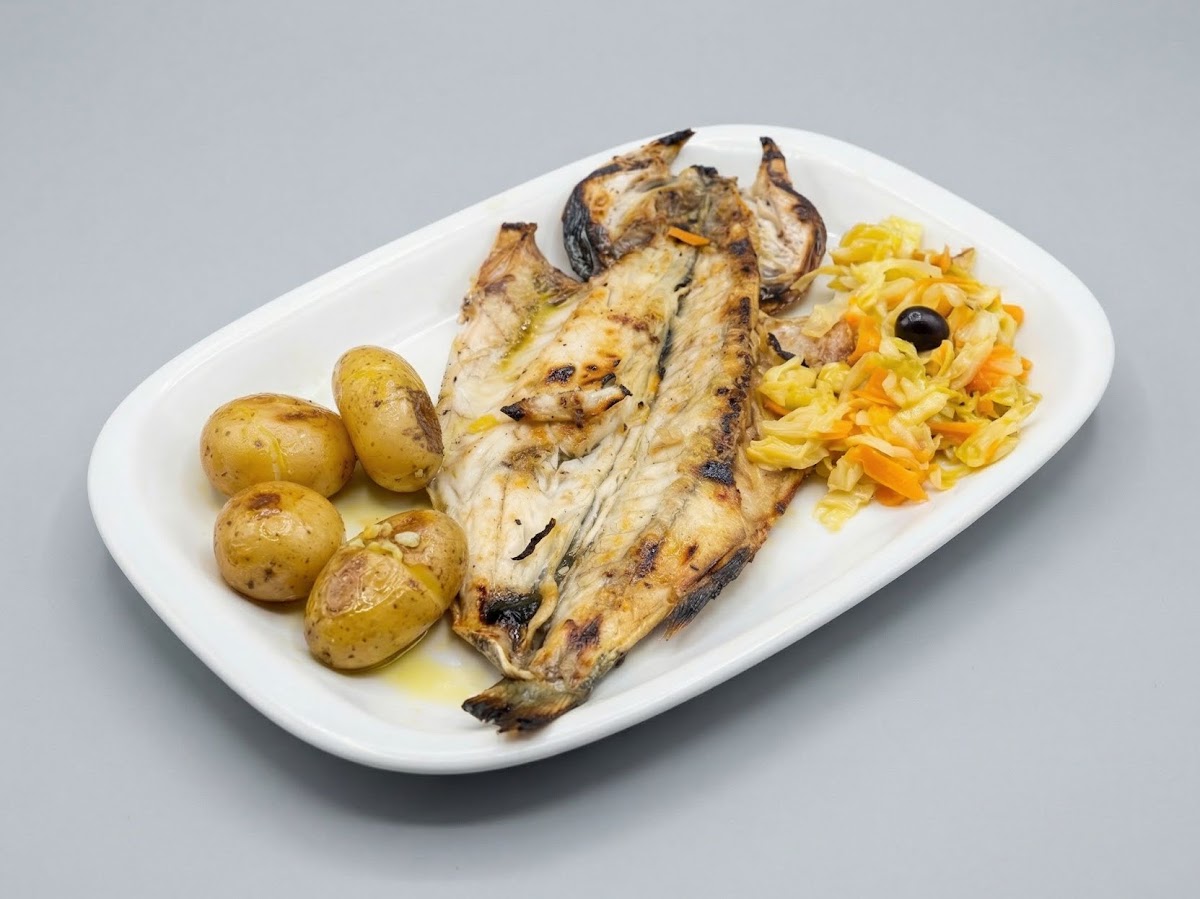 Peixe grelhado servido com batata a murro e salada de couve com cenoura.